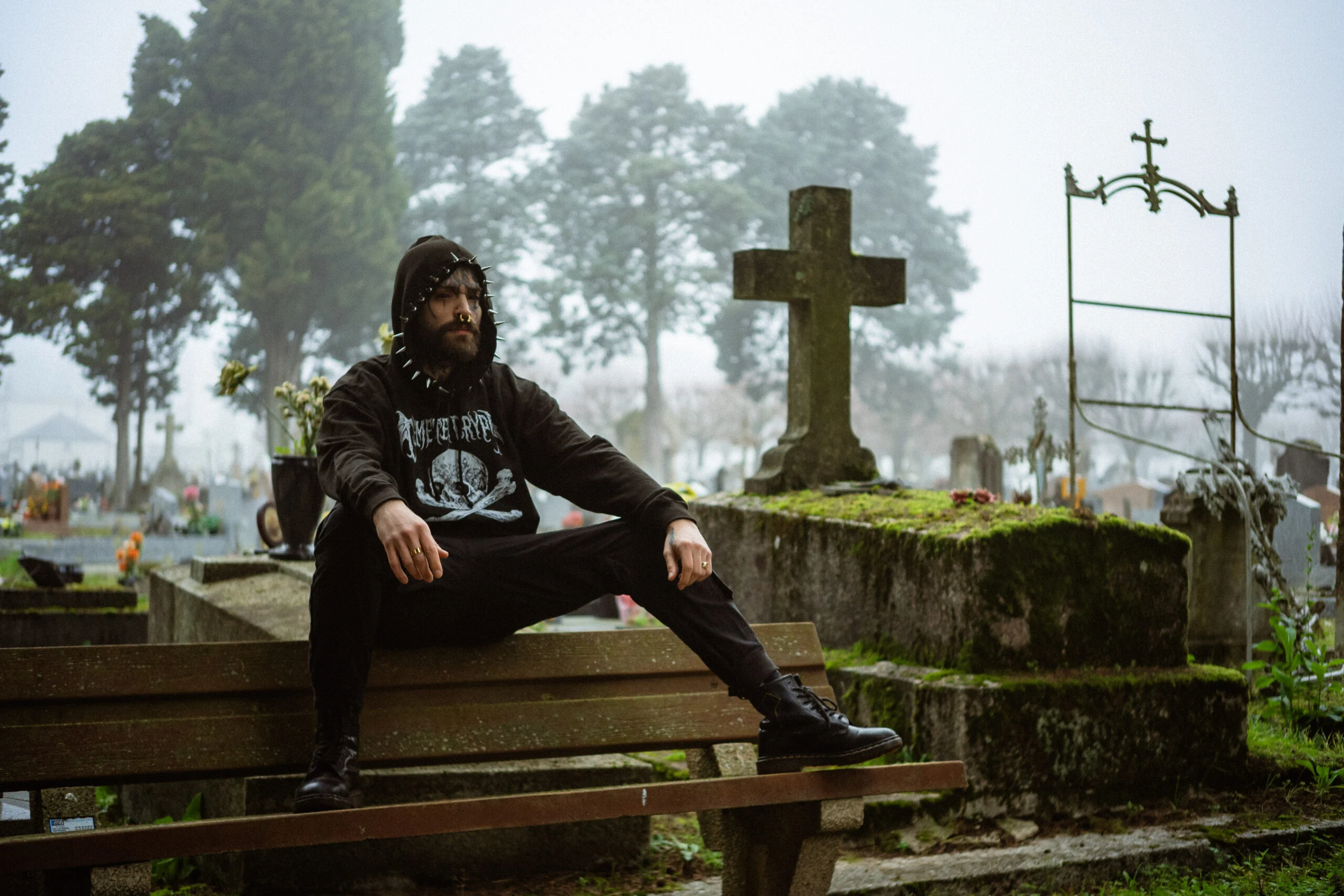 Portrait d’un homme assis sur un banc dans un cimetière brumeux