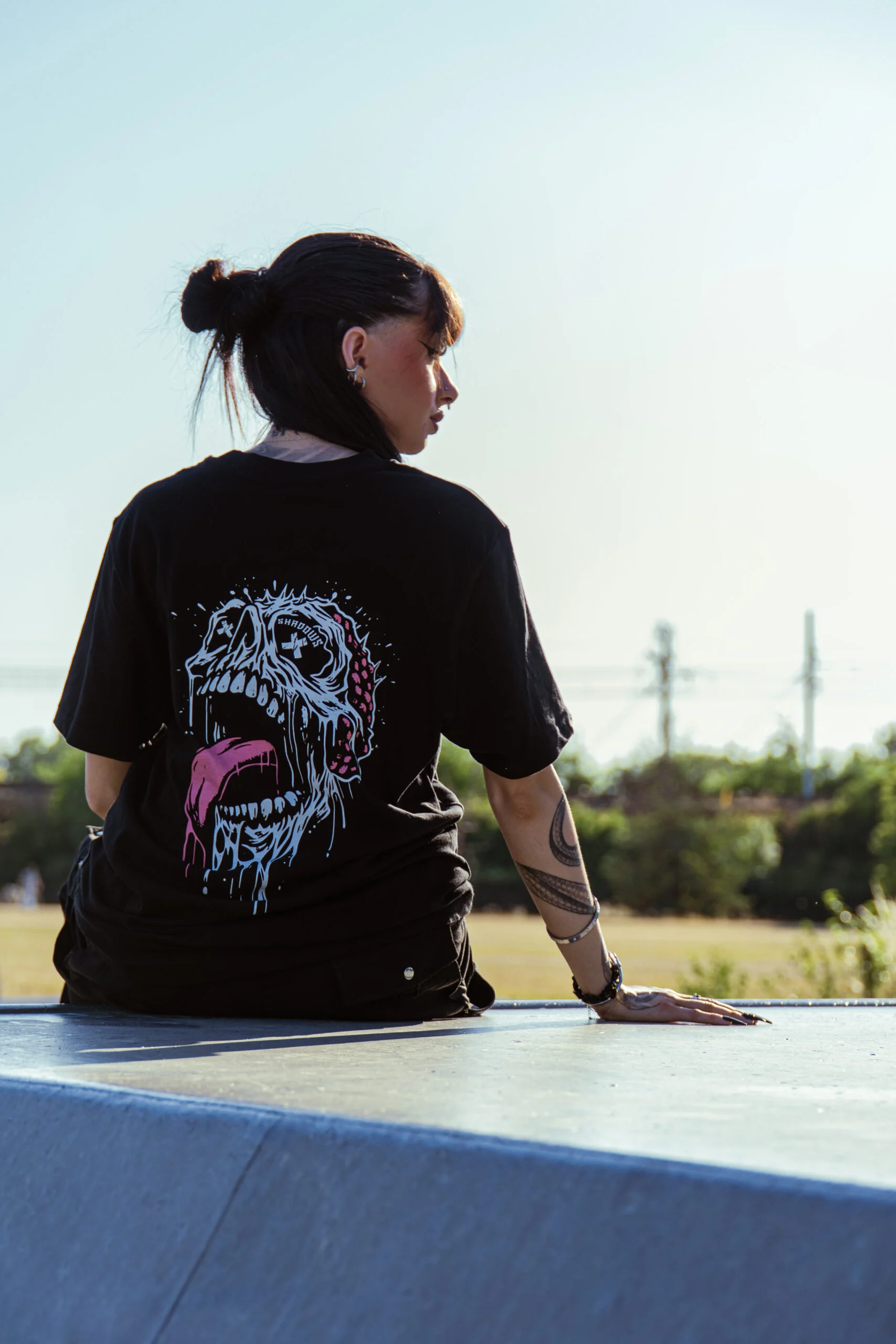 Portrait de dos d’une femme assise dans un skatepark