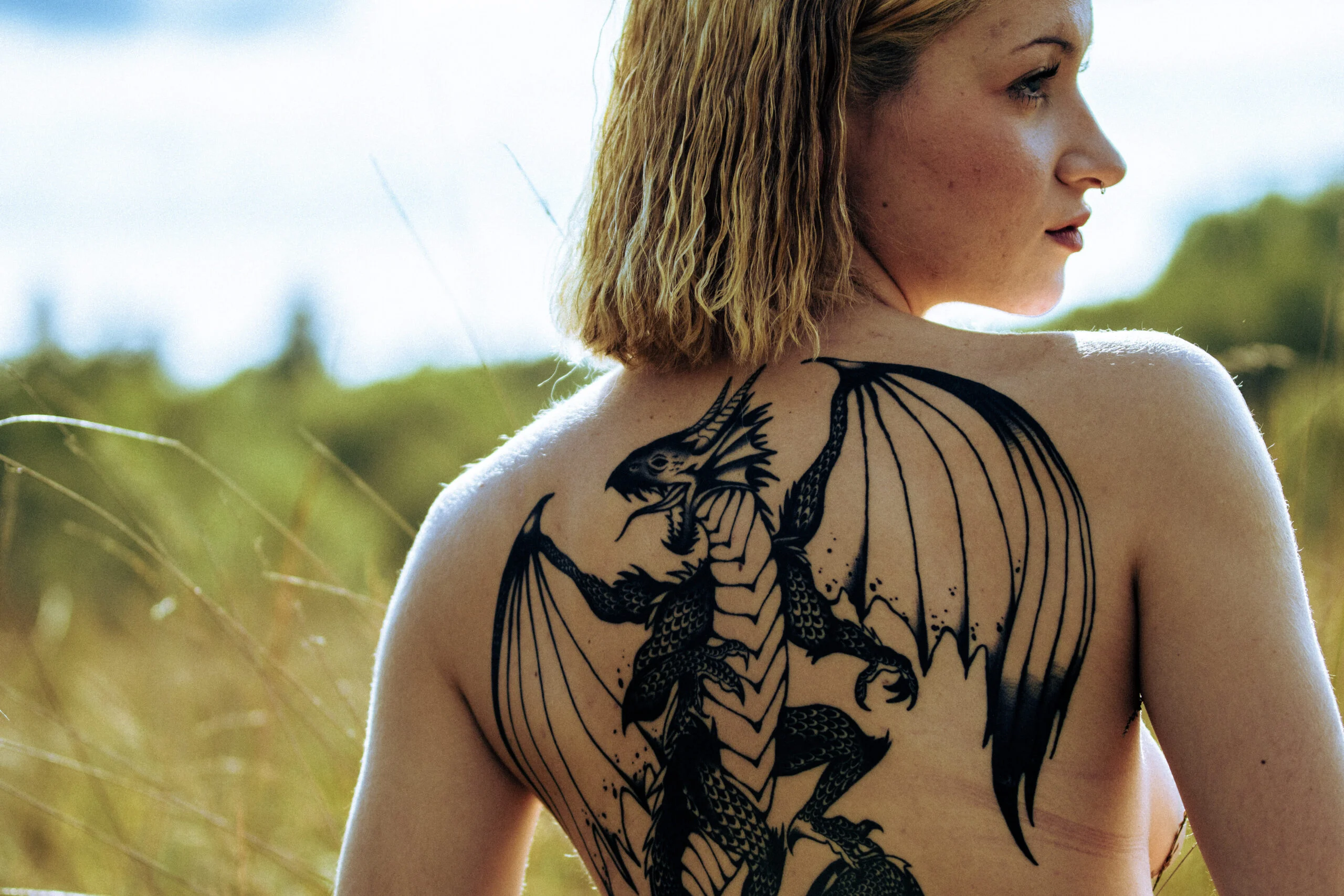 Portrait de dos avec un regard de côté et un tatouage de dragon