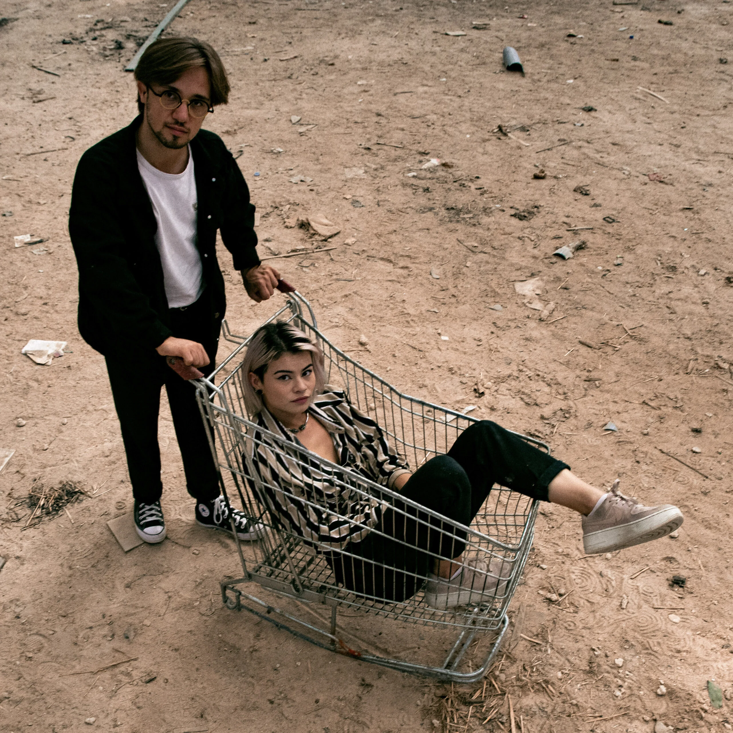 Portrait de deux personnes avec un chariot de supermarché
