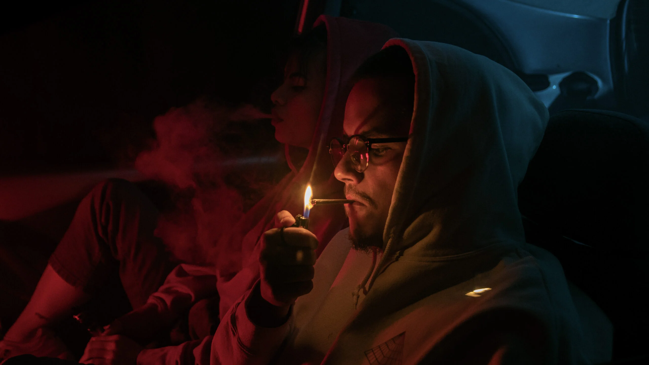 Portrait de deux personnes dans une ambiance sombre aux lumières rouges
