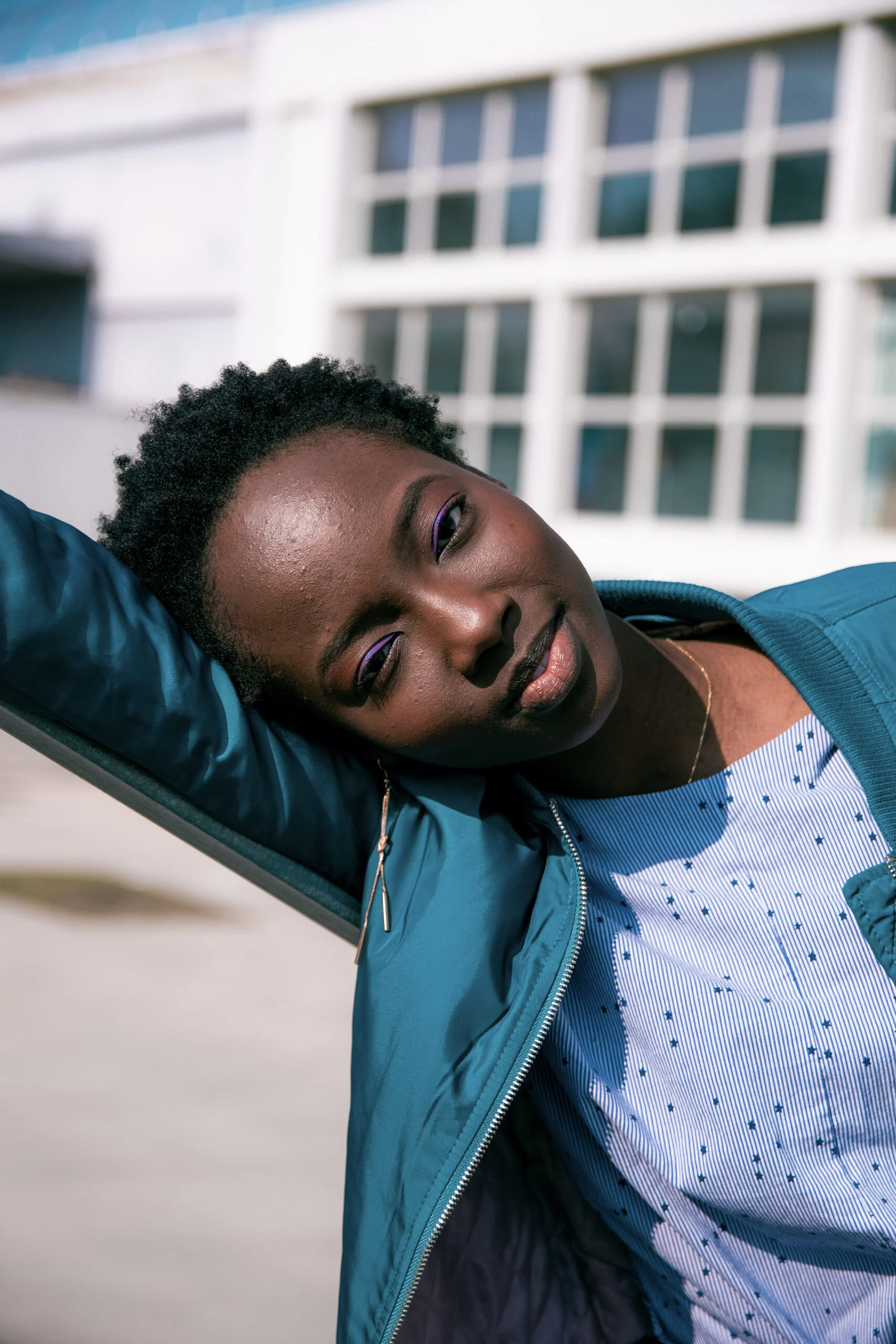 Portrait en veste bleue, la tête appuyée sur un bras