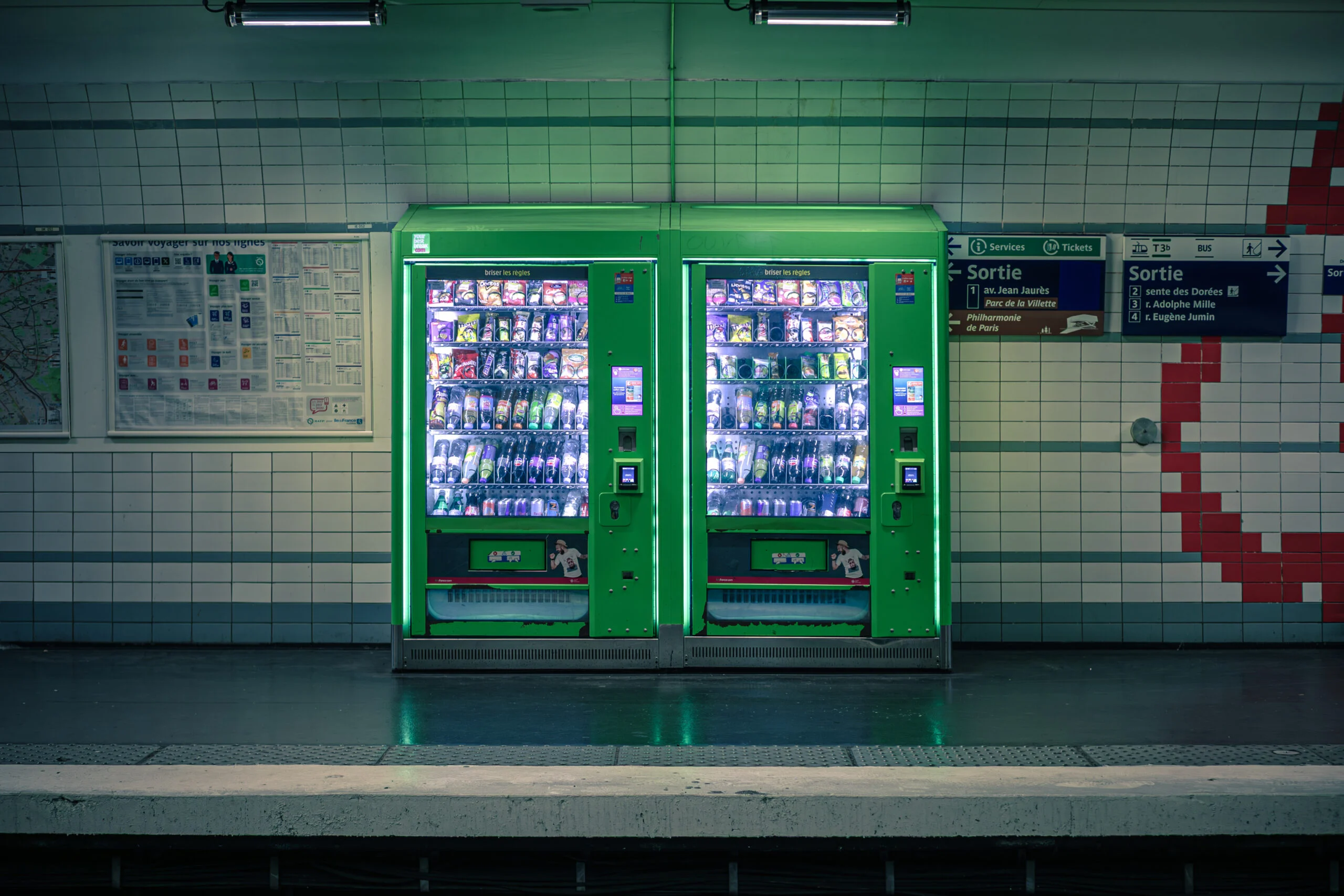 Distributeurs automatiques verts sur un quai de métro