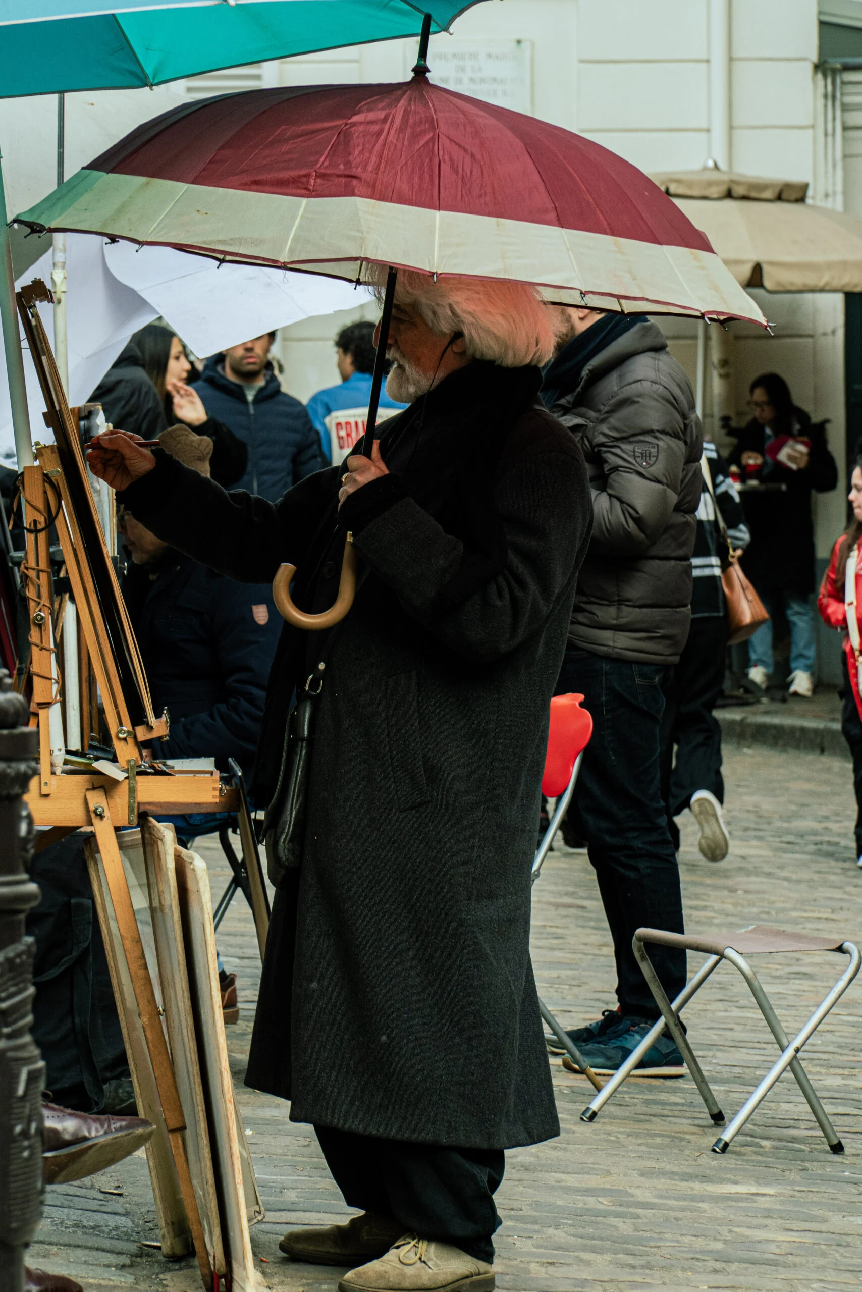 Artiste de rue peignant sous un parapluie
