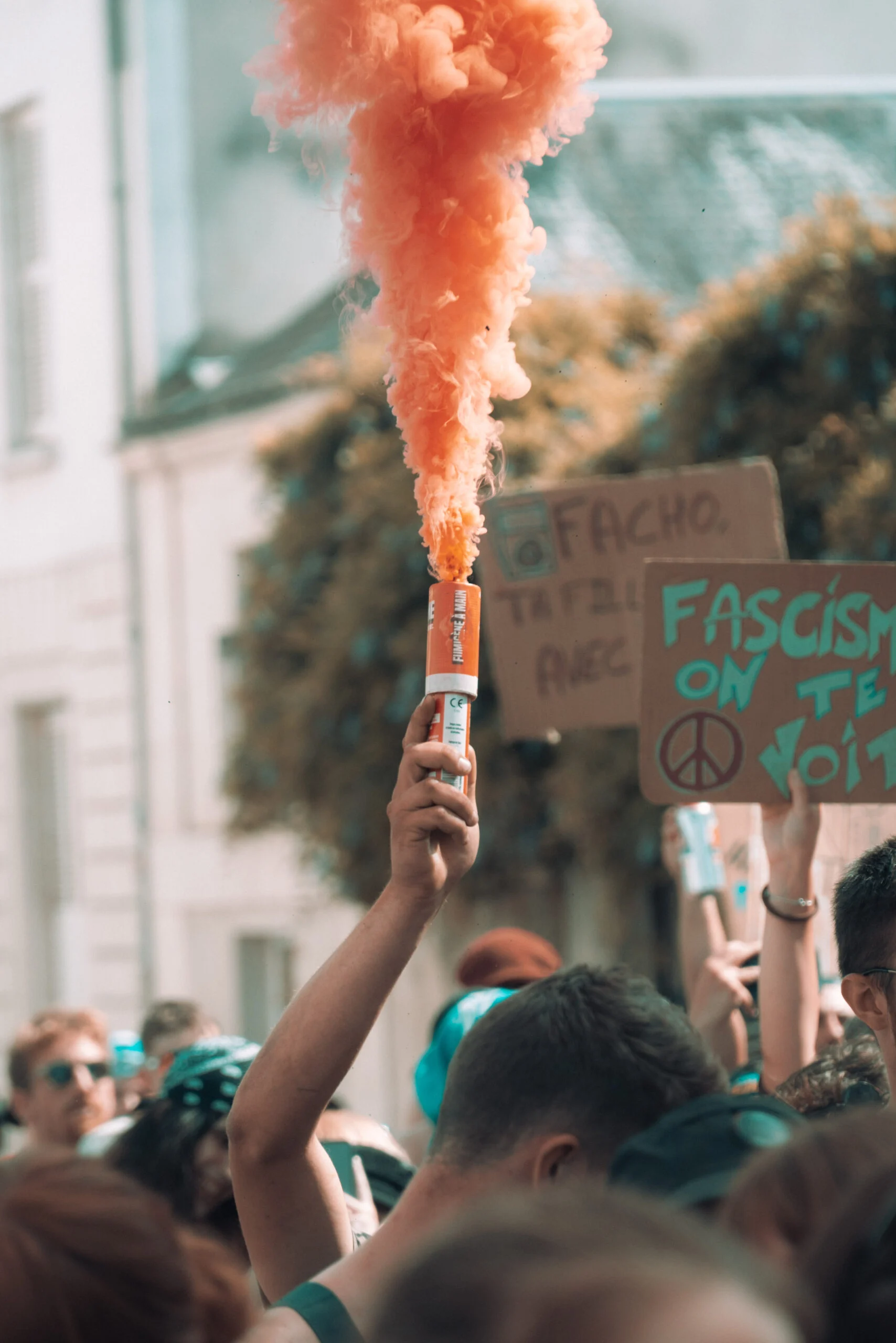 Fumigène orange levé au-dessus d’une foule